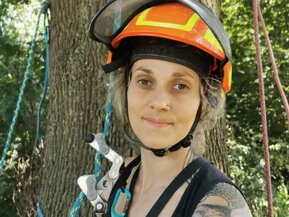 Janis Strahler, Baumpflegerin von Himmelhoch Baumpflege, mit Kletterhelm vor einem Baum